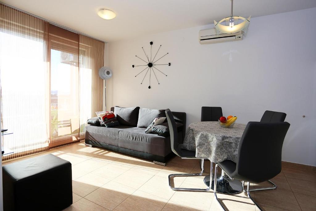 a living room with a couch and a table and a clock at Apartment Iva in Zadar