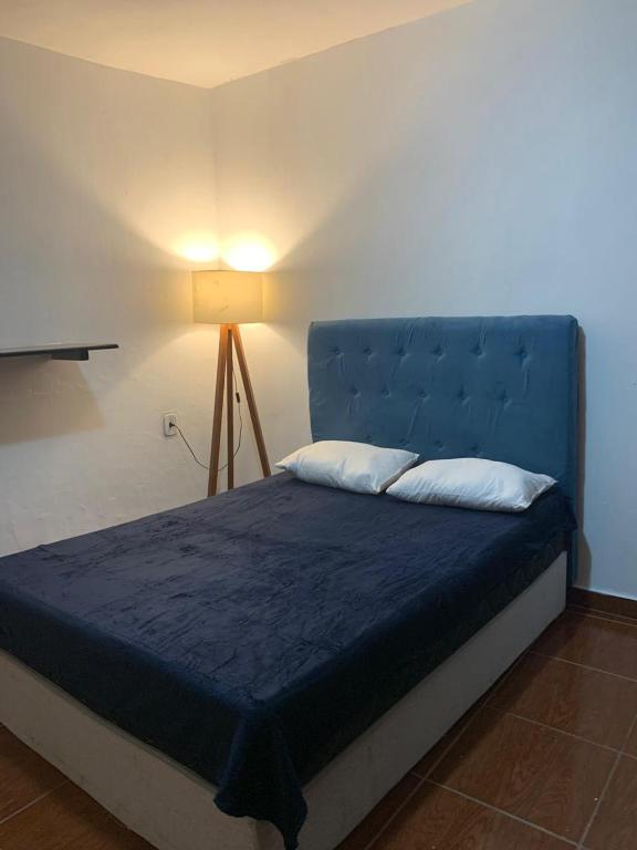 a bed with a blue headboard in a room at Sobiuai 72 in Ouro Preto