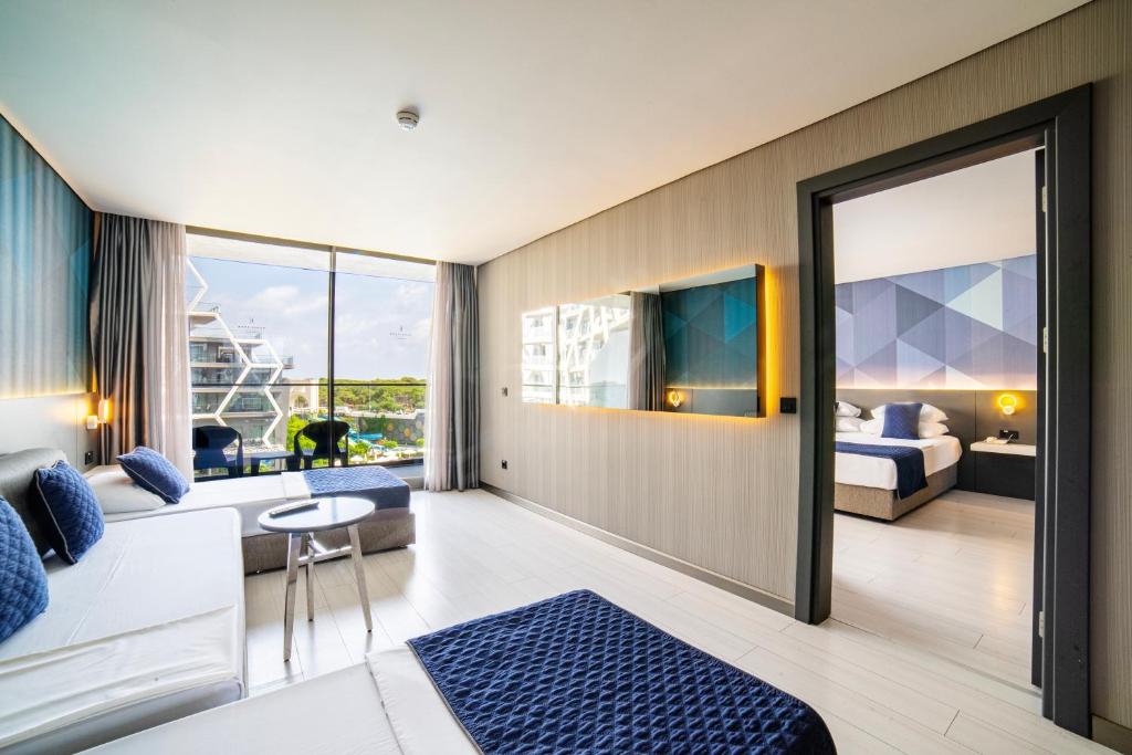 a hotel room with a king bed and a living room at Bosphorus Sorgun Hotel - Ultra All Inclusive in Side