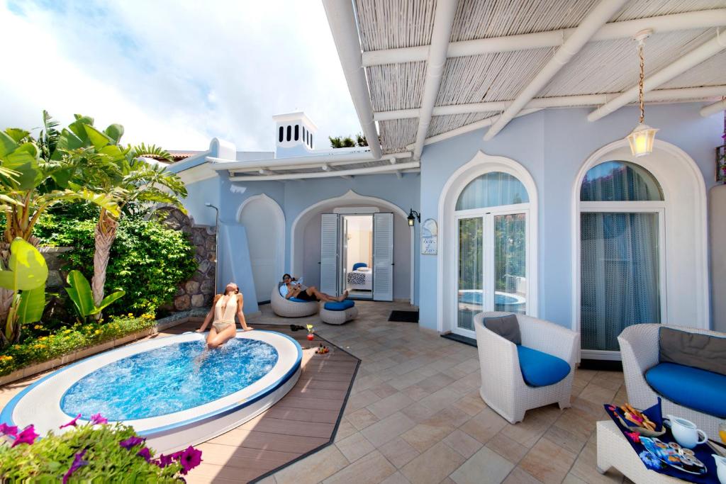 a woman sitting in a pool in a house at Sorriso Thermae Resort & Spa in Ischia
