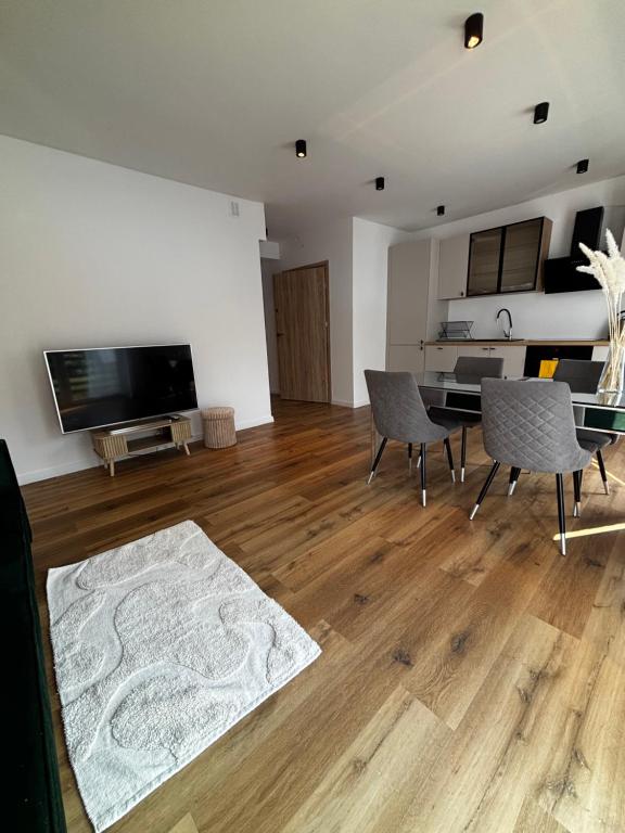 a living room with a table and chairs and a television at Apartament ul Jodłowa Malinka in Opole