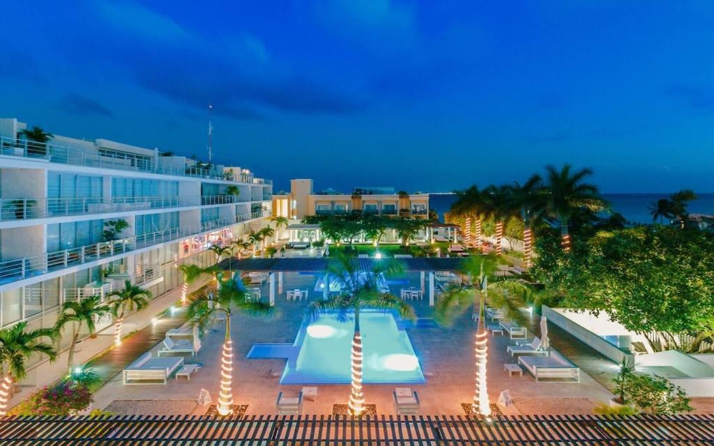 a pool on the side of a hotel at night at Magia Multi Listings in Playa del Carmen