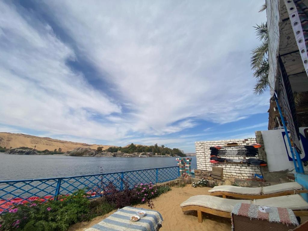 a view of a body of water with some chairs at Hooly Nubian in Aswan