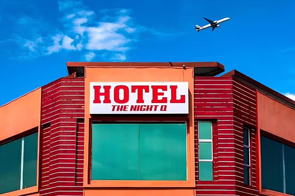 a hotel with an airplane flying over a building at Night Queen Express Hotel KLIA T1 and KLIA T2 in Sepang
