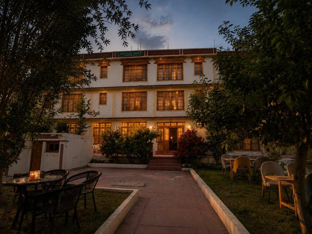 a building with tables and chairs in front of it at Zotpa Hostel in Leh