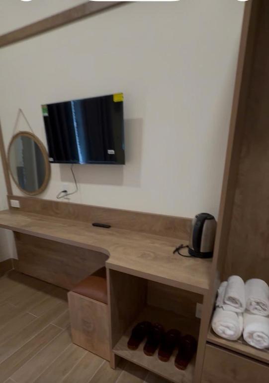 a room with a desk with a television and shoes at Minh's homestay in Long Bình
