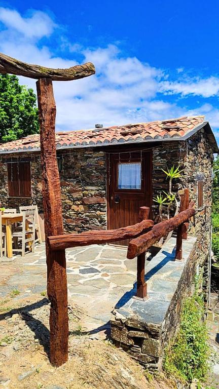 a wooden bench sitting in front of a building at Refúgio do Casal in Lousã