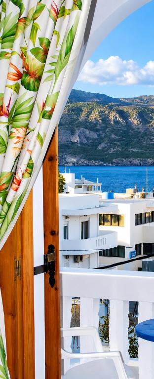 an open door to a balcony with a view of the ocean at Sea Stone Apartments in Karpathos