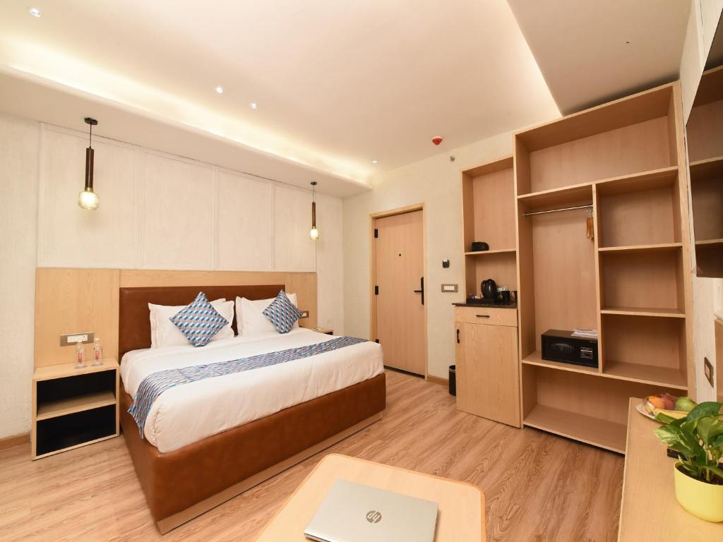 a bedroom with a large bed and a desk with a laptop at Palette Hotel by CheckIn Amritsar, Airport Road in Amritsar