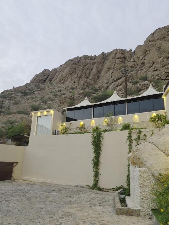 a white fence with a mountain in the background at Wadi Bani Khalid Oasis in Dawwah
