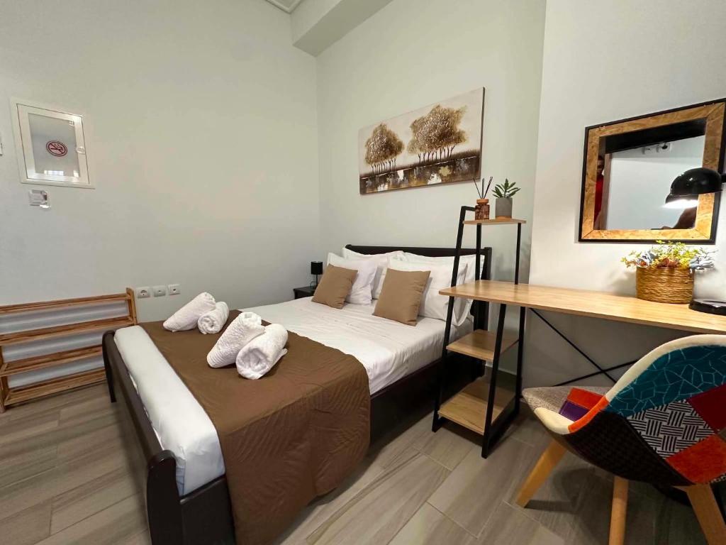 a bedroom with a bed and a table and a desk at Breeze Apartments Megara - Nest in Megara