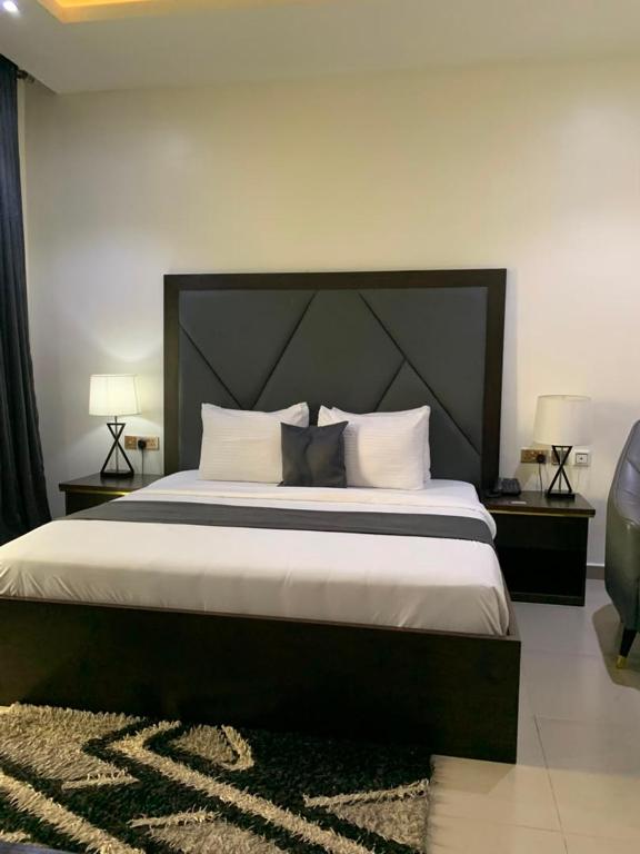 a bedroom with a large bed with white sheets and pillows at Corporate Residence in Port Harcourt