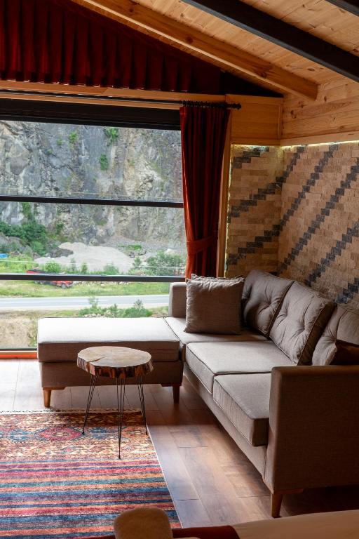 a living room with a couch and a large window at Gale Suit in Çamlıhemşin