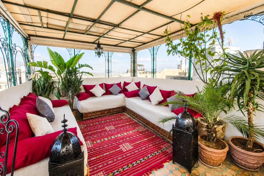 a living room with a white couch and red pillows at Dar Omar in Fez