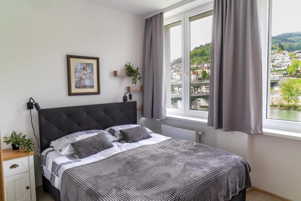 a bedroom with a bed and a large window at Prenočišča Dany in Dravograd