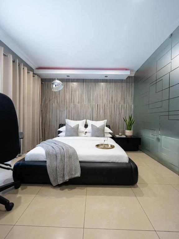 a bedroom with a large bed and a chair at The Seamless Oasis in Cape Town