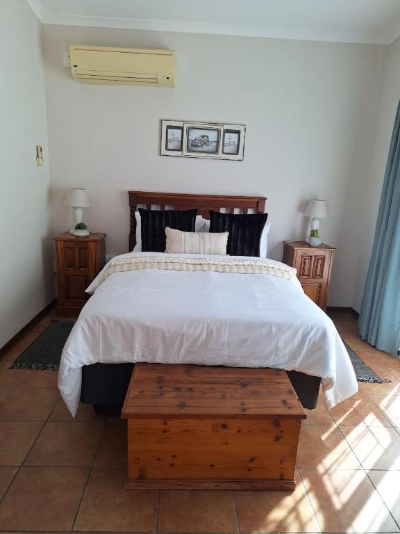 a bedroom with a large bed and two night stands at Cozy Room in Ellisras