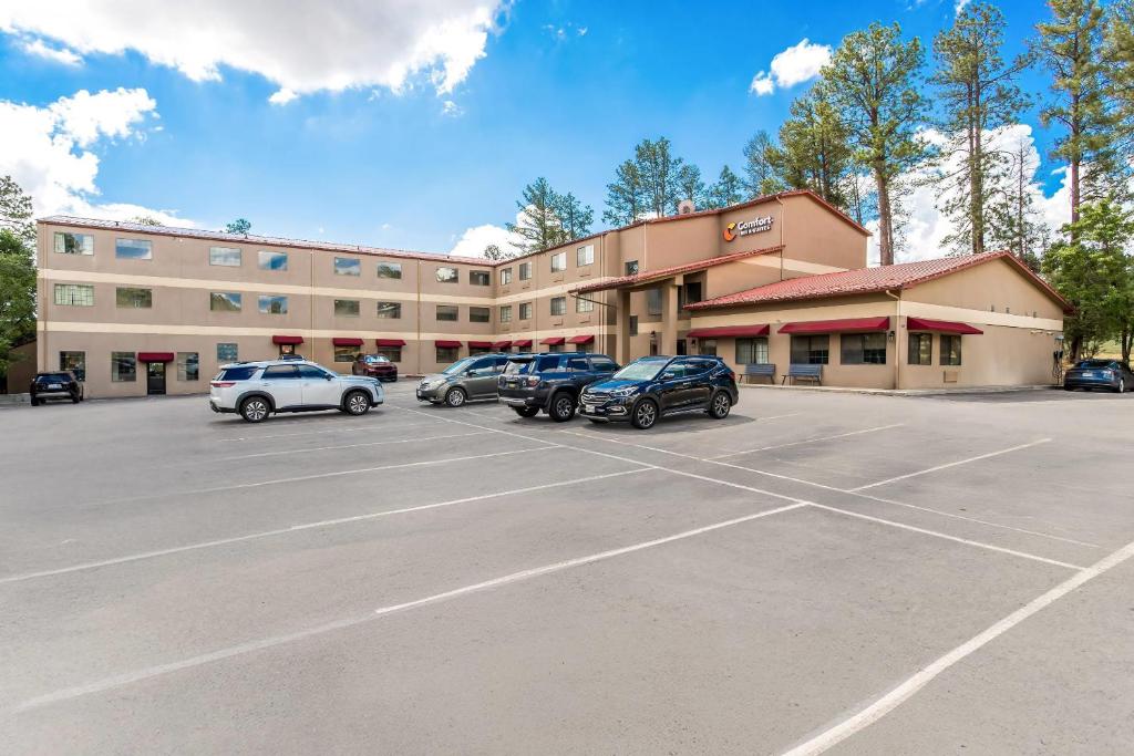 a parking lot in front of a building with cars parked at Comfort Inn & Suites Midtown in Ruidoso