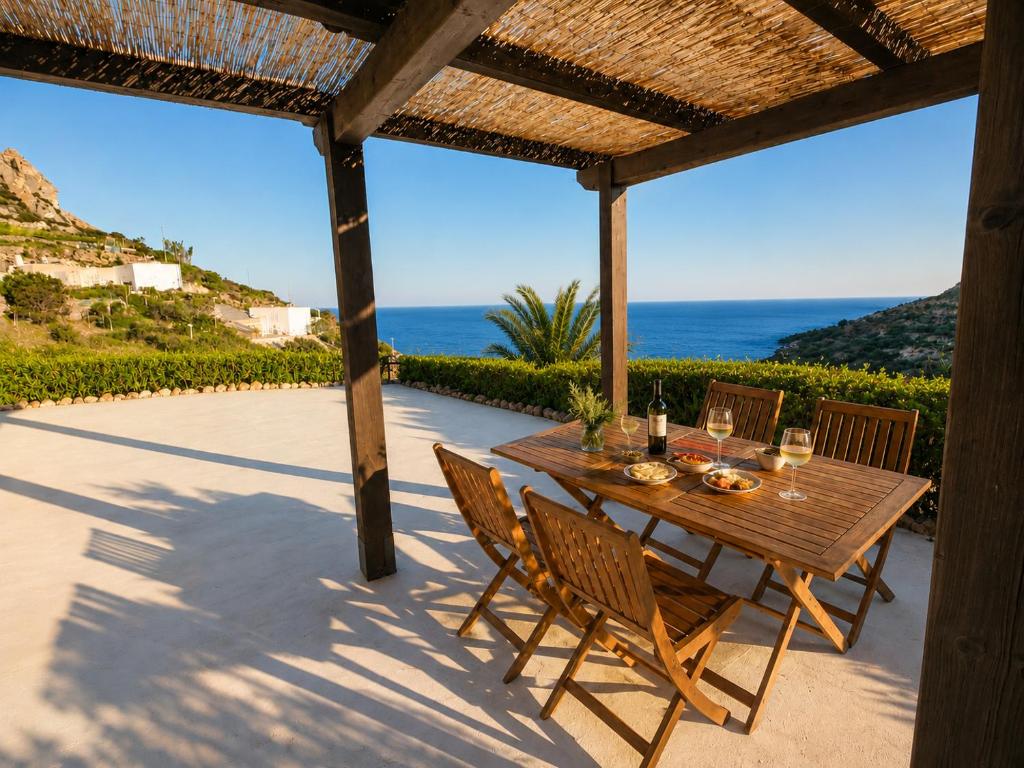 a wooden table and chairs on a patio with the ocean at Maridea - Vairone in Ponza