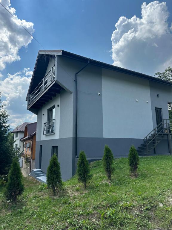a white building with a balcony on the side of it at Grey House in Slavske