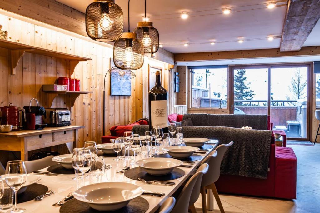 a dining room with a table with wine glasses at Chalet Vithos en Demi-pension in Les Bruyères