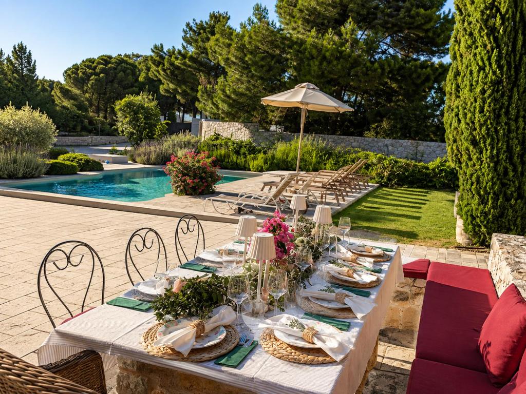a table with plates of food on it next to a pool at Wine & Vineyard Retreat Emarmene in Koskinou