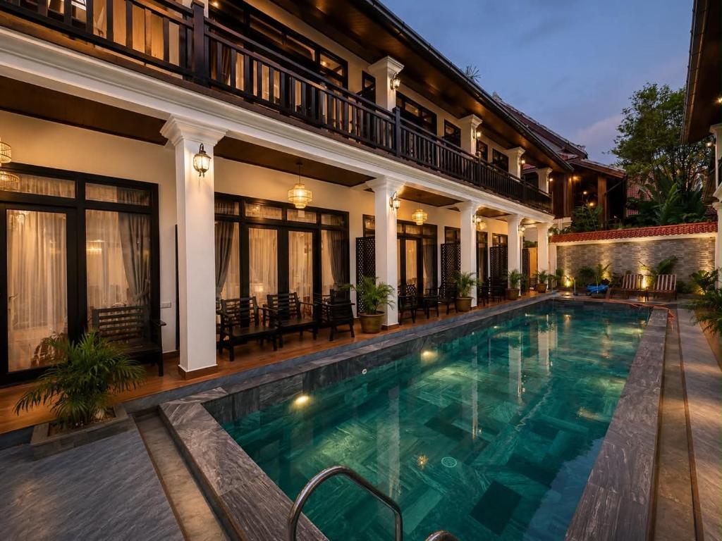 a swimming pool in front of a house at Luang Prabang Indochine Heritage Hotel in Luang Prabang