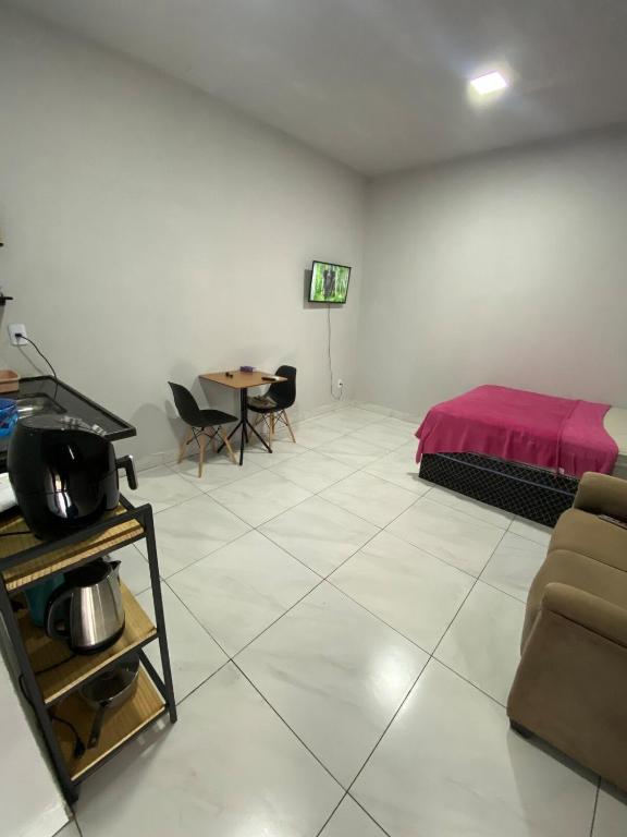 a living room with a bed and a table at silencioso e aconchegante in Rio Verde