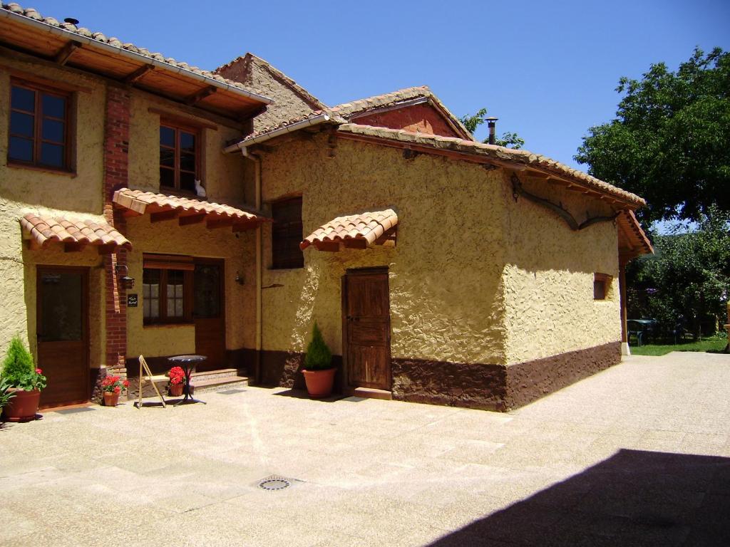 a large house with a patio in front of it at El Porma in Villanueva del Condado