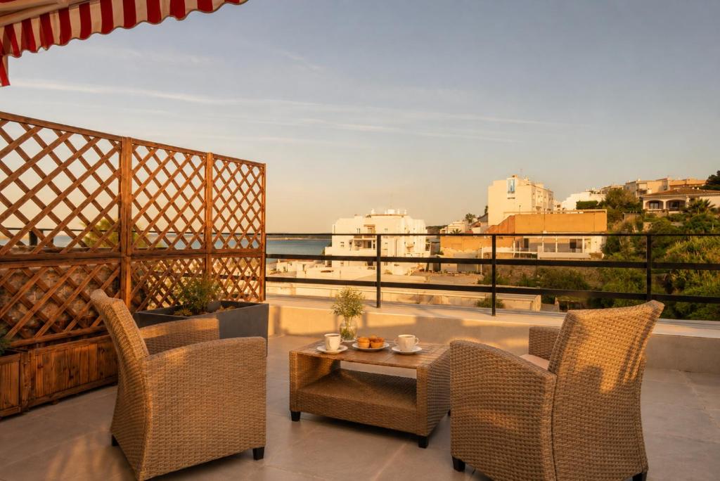 a patio with chairs and a table and a view of the ocean at Panther Home Manantial in El Puerto de Santa María