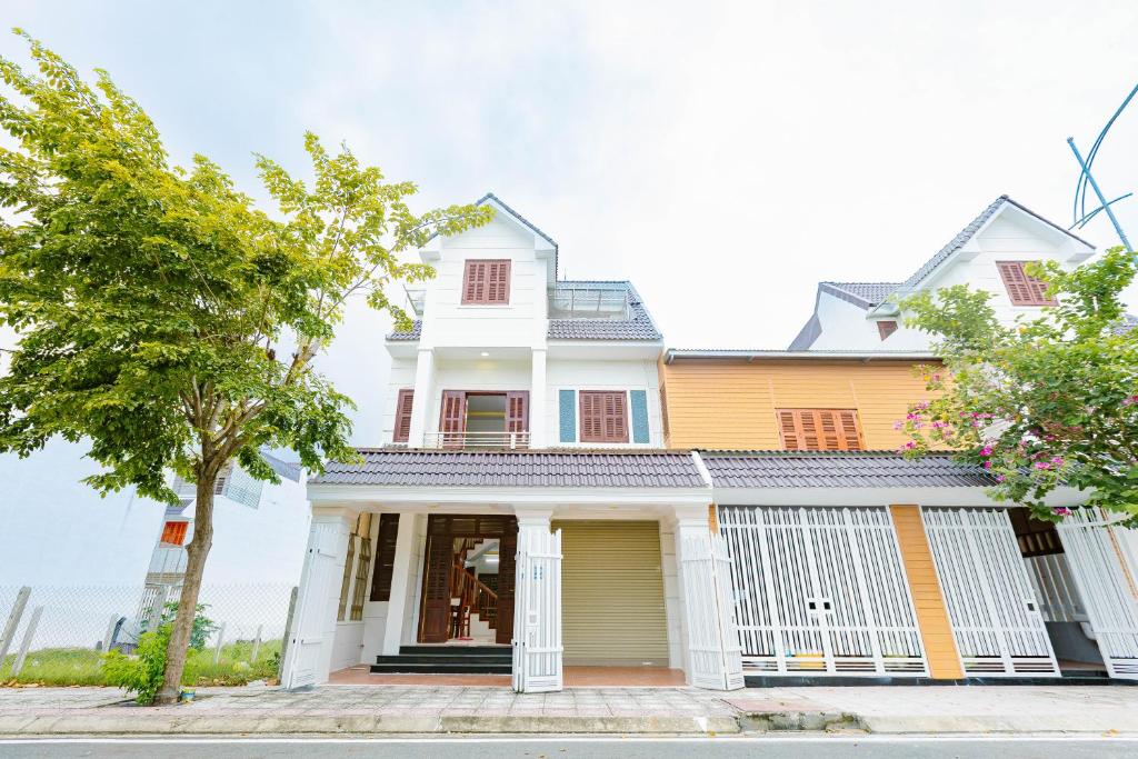 a white and yellow house with a tree at BTLk D16- 27-02 in Thủy Triều