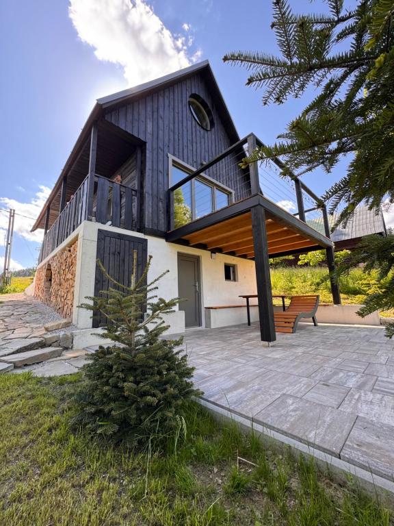 a house with a large balcony on top of it at Chata Slovena in Novoť