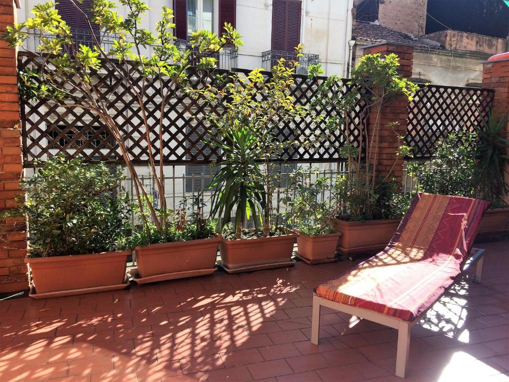 カターニアにあるLa Casa del Nespoloの塀と椅子と植物のあるパティオ