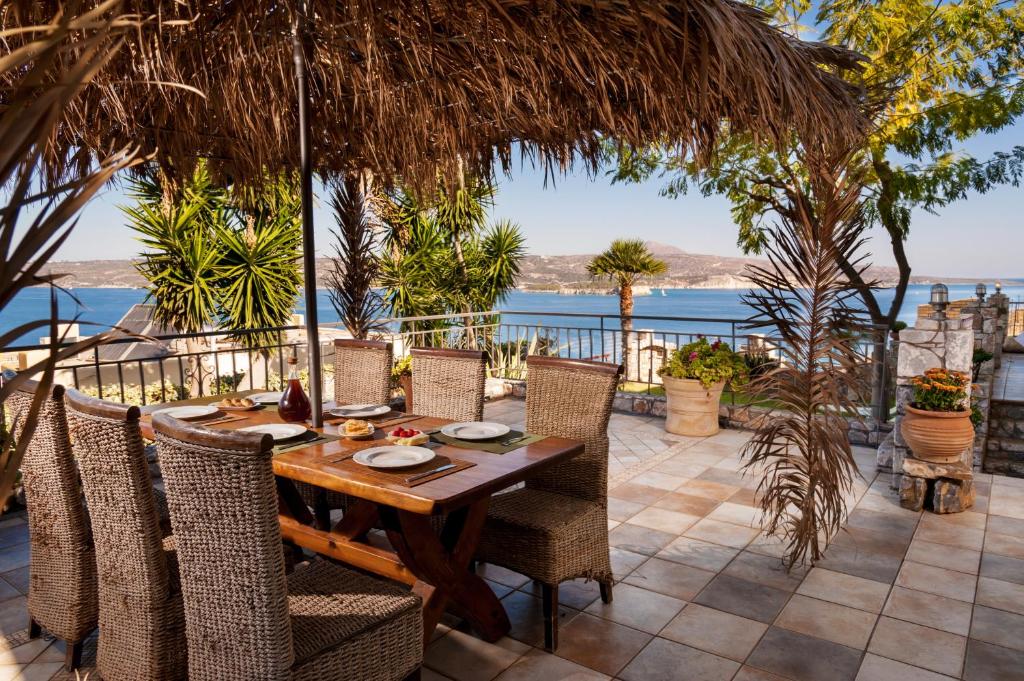 mesa de comedor con sillas y vistas al océano en Villa Thalassea, en Kalami