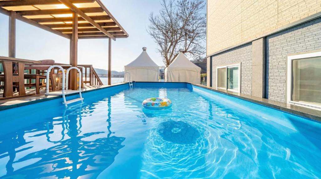 a swimming pool with a boat in the water at Chuncheon El Dorado Kid's Pension in Gapyeong