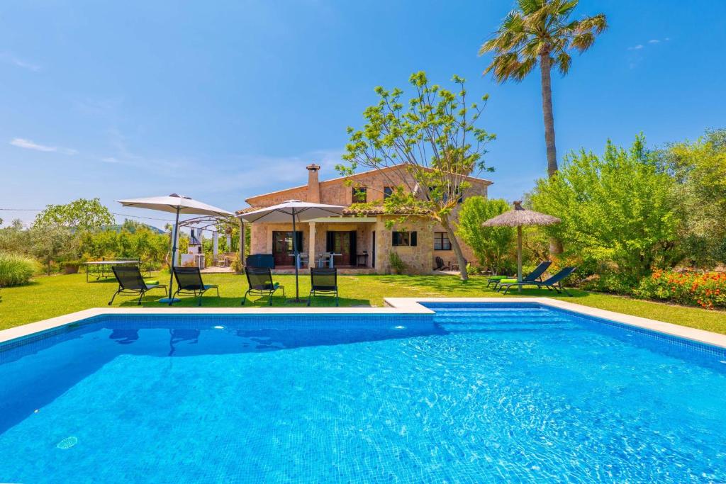 a swimming pool in front of a house at Mercader in Alcudia