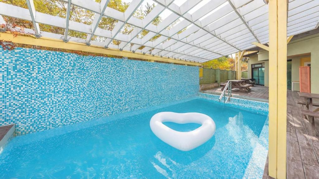 a swimming pool with a white chair in the water at Gangleung laimbichipensyeon in Gangneung