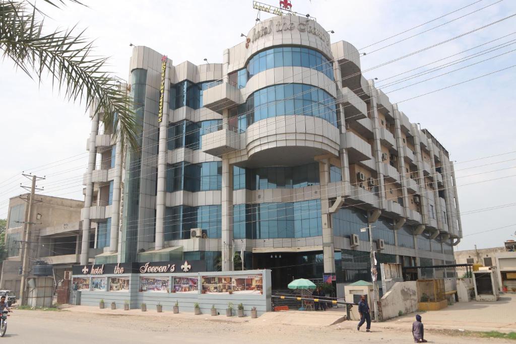 a building with people walking in front of it at Hotel the Jeeven's in Sialkot