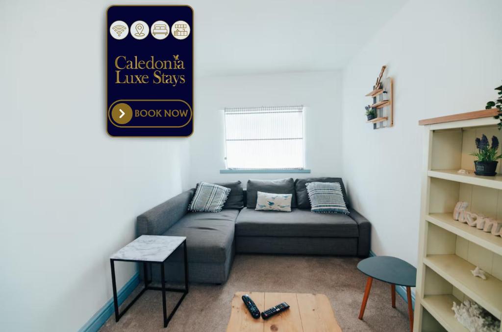 a living room with a couch and a sign at The Graigfryn Hideaway in Amlwch