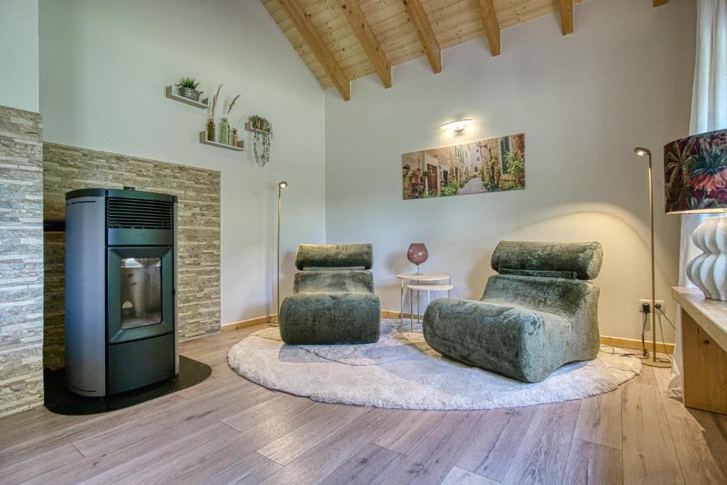 a living room with two chairs and a fireplace at Ferienhaus Immenhof in Rieden