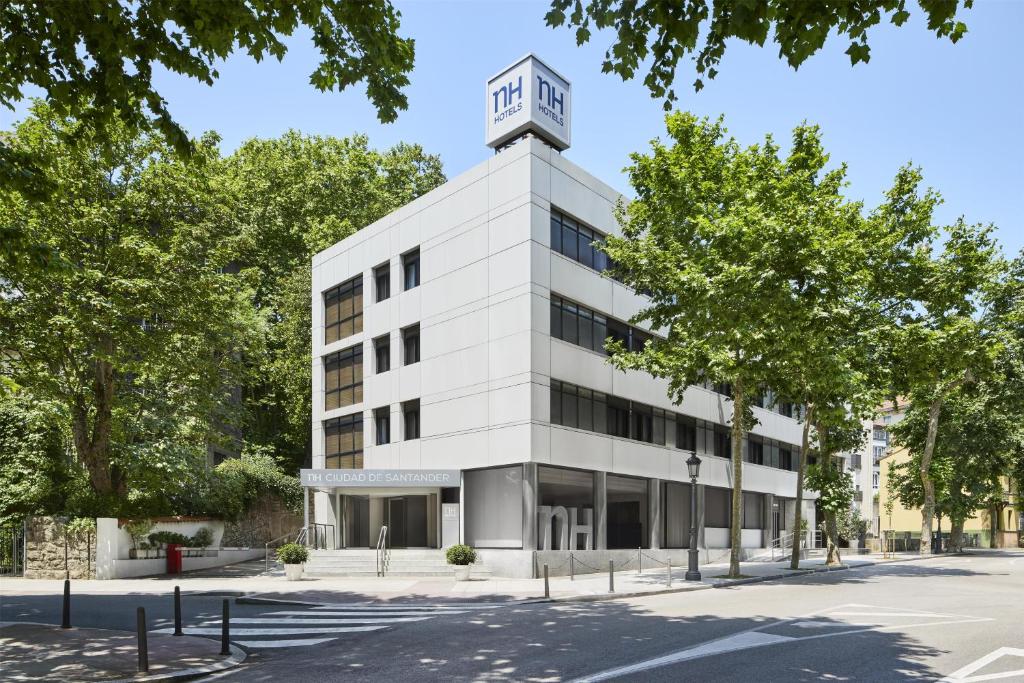 an office building with a clock tower on top at NH Ciudad de Santander in Santander