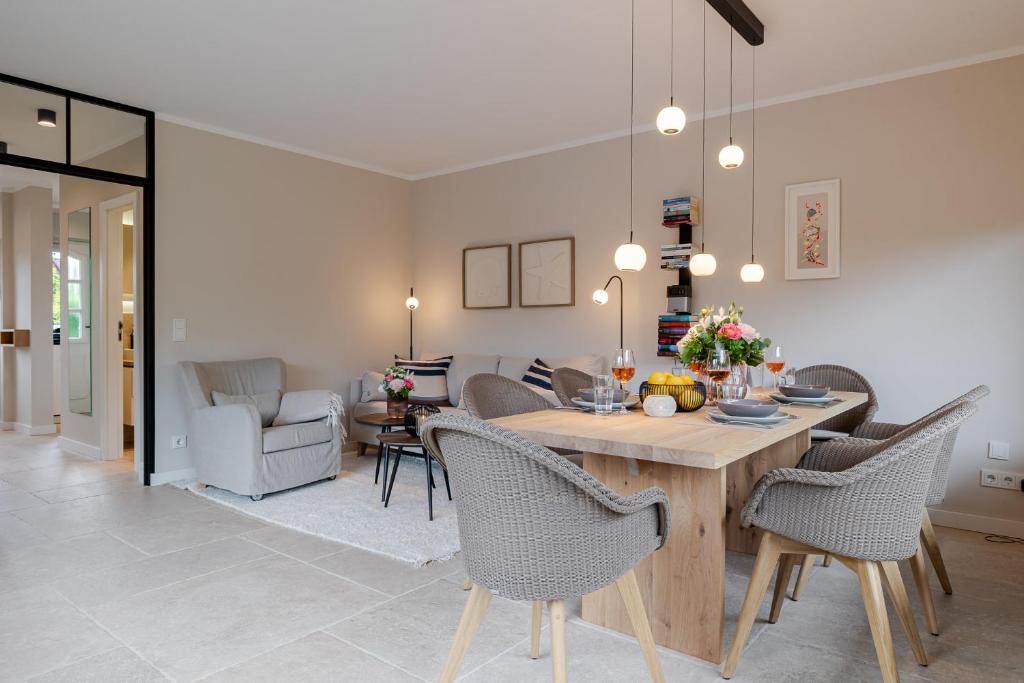 a dining room and living room with a table and chairs at Dolle's Hüs in Wenningstedt