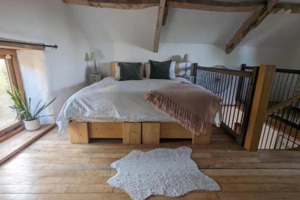 a bedroom with a large bed and a rug at 1 Bed Barn - Sleeps 2 - Pool - Garden - Bbq in Taunton