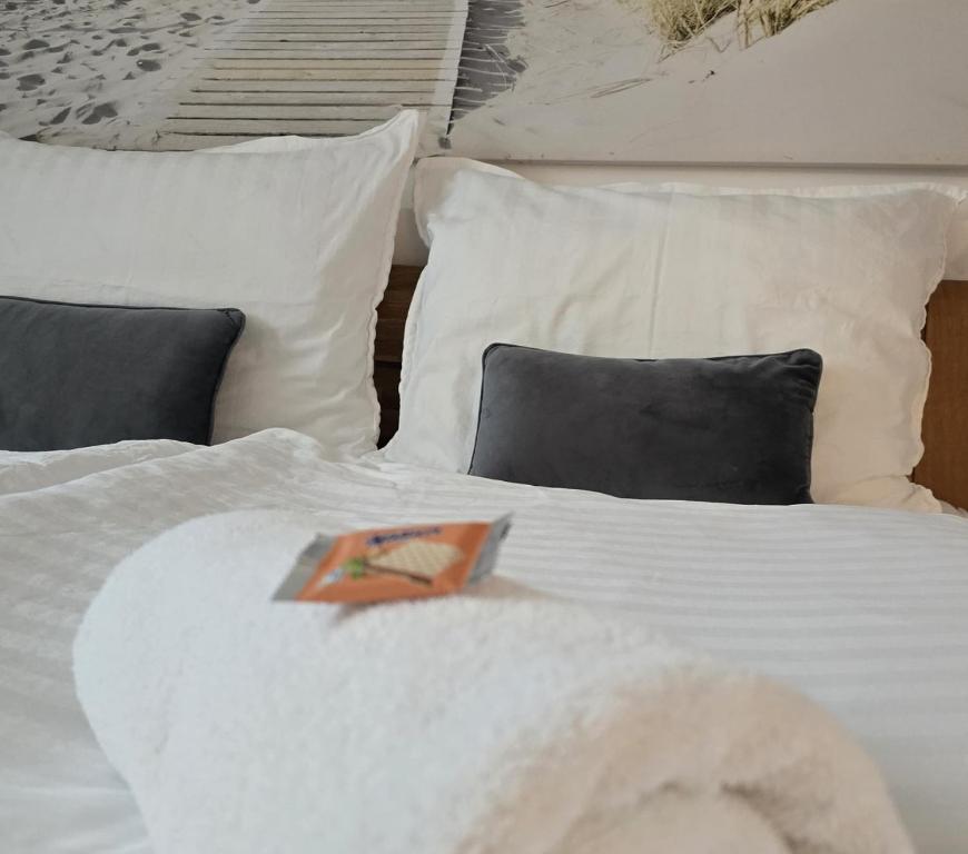 a white bed with pillows and a book on it at Dreamly Suites Oslip in Oslip