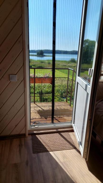an open door to a screened in porch with a view at Ezermala in Dagda