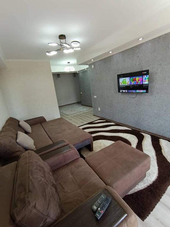 a living room with a couch and a flat screen tv at Urban in Bishkek