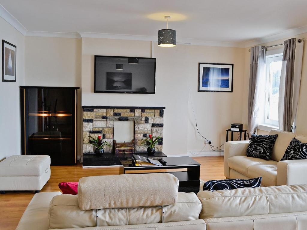 a living room with two couches and a fireplace at Seaview in Oban