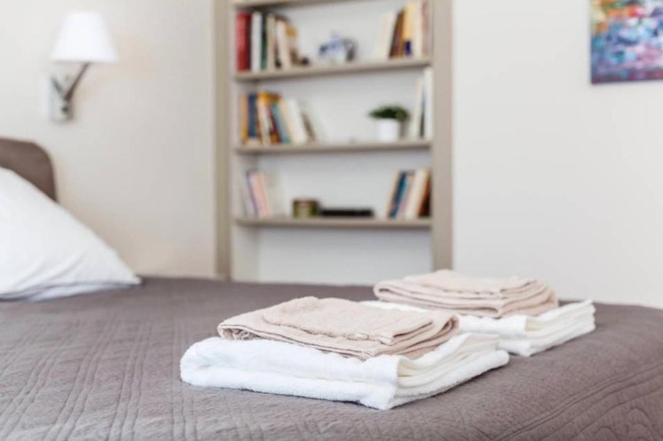 a pile of towels sitting on top of a bed at 1 Square du Docteur Blanche - Paris 16 in Paris