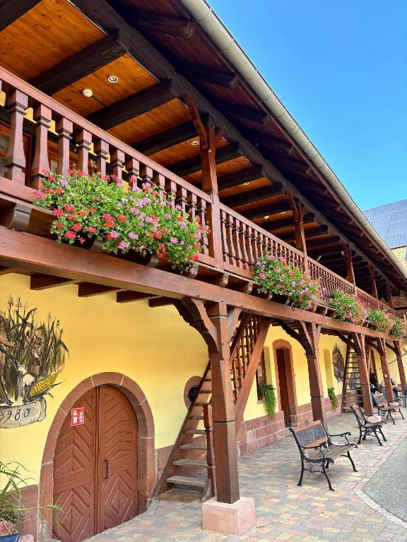 a building with a balcony with flower boxes on it at Chambres d'hôtes chez Adam 