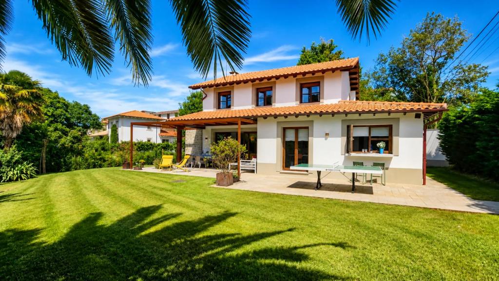 a house with a lawn in front of it at Villa Costa Cue in Cue